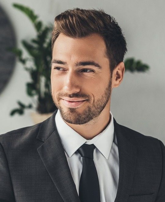 happy-young-businessman-with-cup-of-coffee-at-offi-JB7JNZ8.jpg